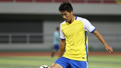 A head-and-shoulders photo of a young, athletic, and focused-looking player in a yellow jersey with a blue stripe...