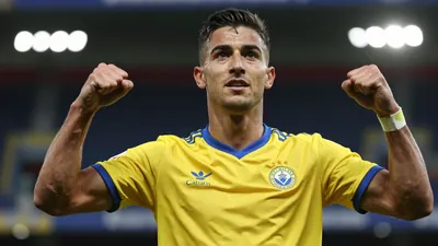 A UD Las Palmas player in a yellow jersey celebrating a goal